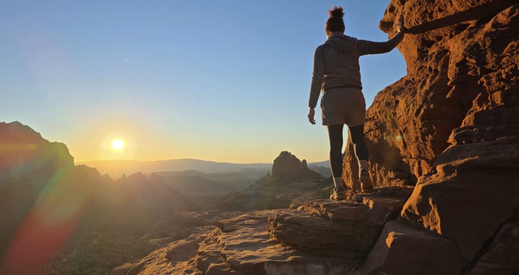 Sedona’s Magic Goes Global: Safari Jeep Tours Featured in The Canberra Times 2 A person on top of the Red Rocks facing the horizon