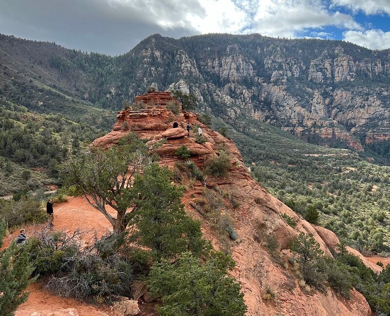 the stunning red rock formations of Sedona, Arizona, with dramatic cliffs in the background, vibrant desert vegetation, and a clear blue sky, capturing the essence of an off-road adventure in a breathtaking landscape. 